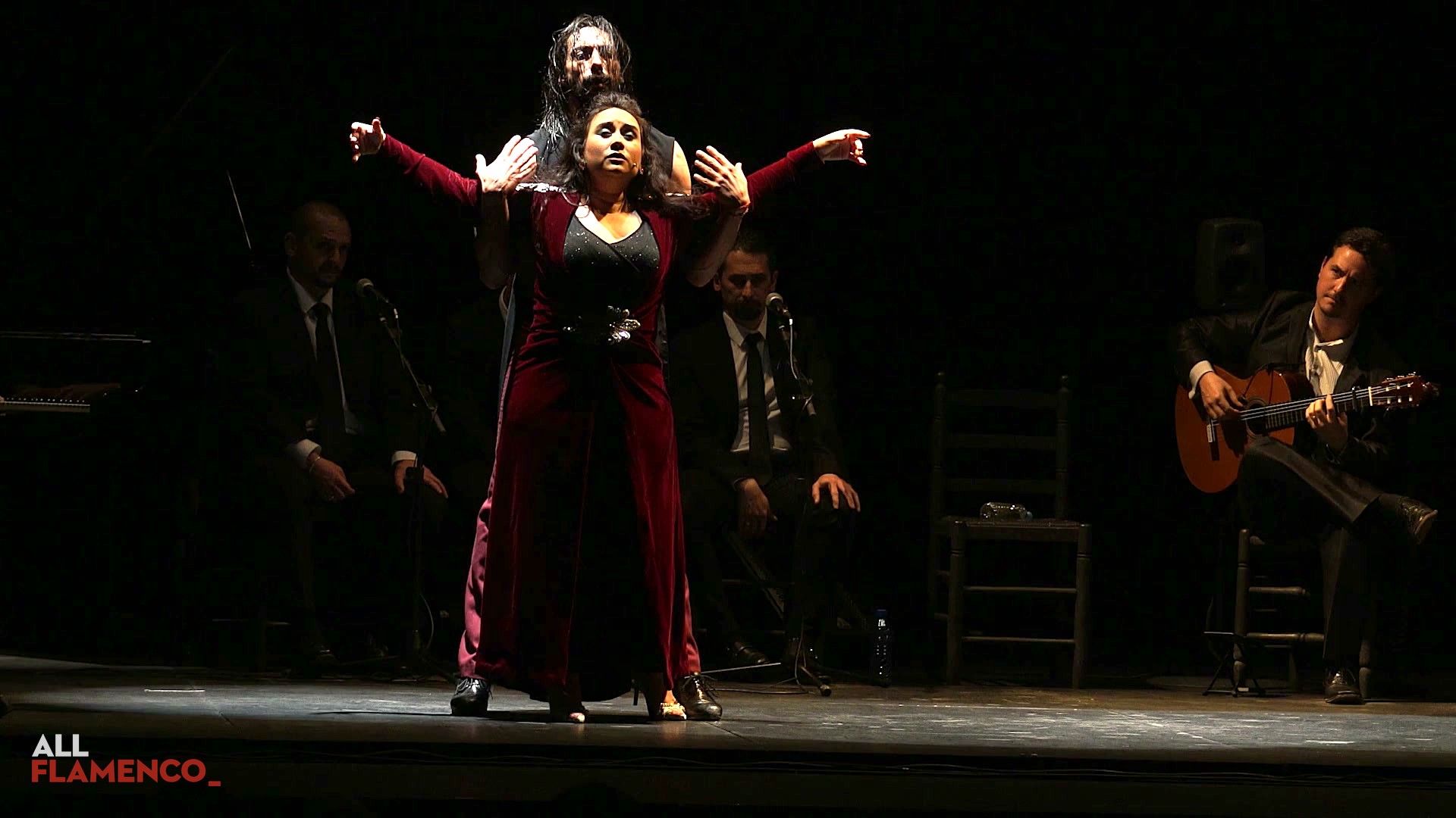 Eduardo Guerrero, standing behind Encarna Anillo, reaches his arms over the singer's shoulders in «Poema 15»